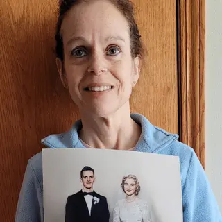 A customer holding their restored photo