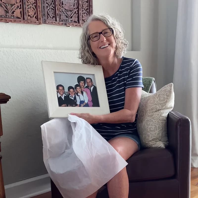 A customer holding their restored photo