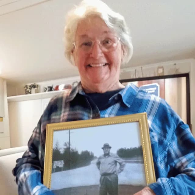 A customer holding their restored photo